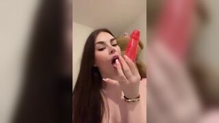 Adorable Babe Deeply Sucks a Dildo While Bouncing on Bed Video