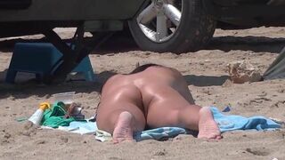 Beautiful nude woman enjoys the sun on the nudist beach