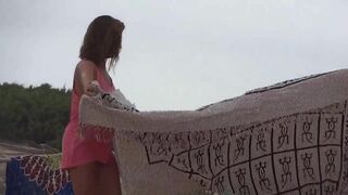 Beautiful MILF strips completely nude on the beach filmed voyeur